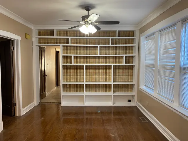 a view of a livingroom with wooden floor and a ceiling fan