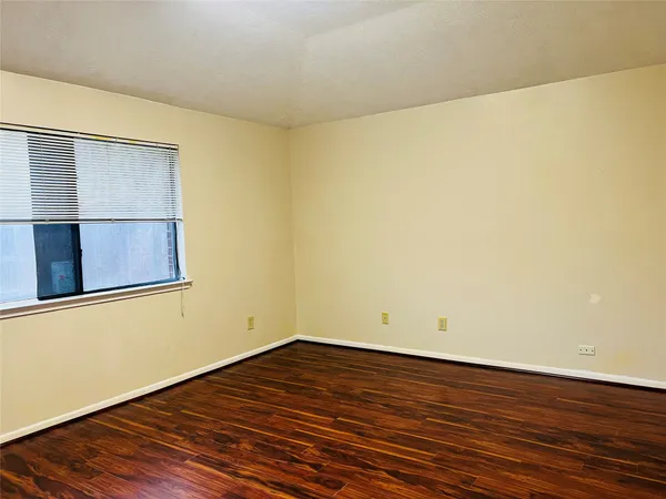a view of a room with wooden floor and a window