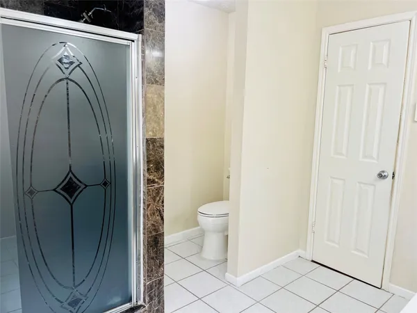 a bathroom with a toilet and a shower