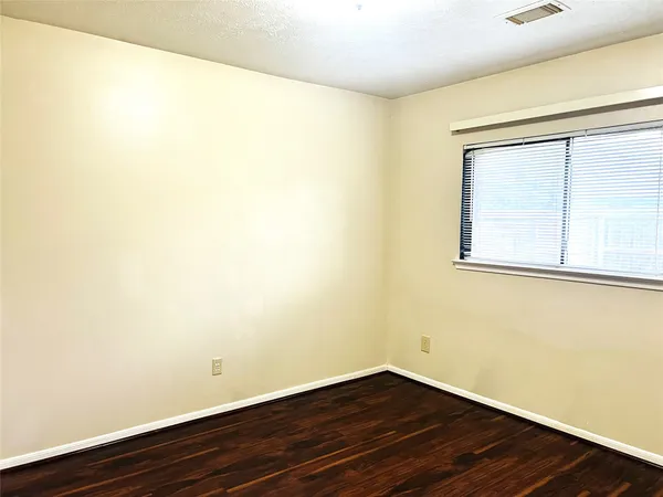 a view of a small space with wooden floor and a window