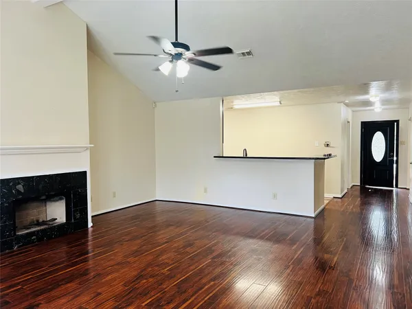 a view of empty room with wooden floor and fireplace
