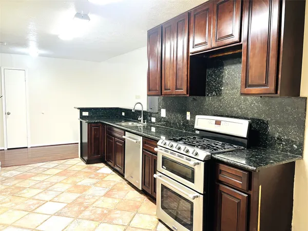 a kitchen with granite countertop stainless steel appliances and wooden cabinets
