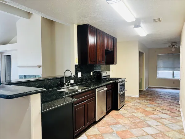 a kitchen with granite countertop stainless steel appliances and sink