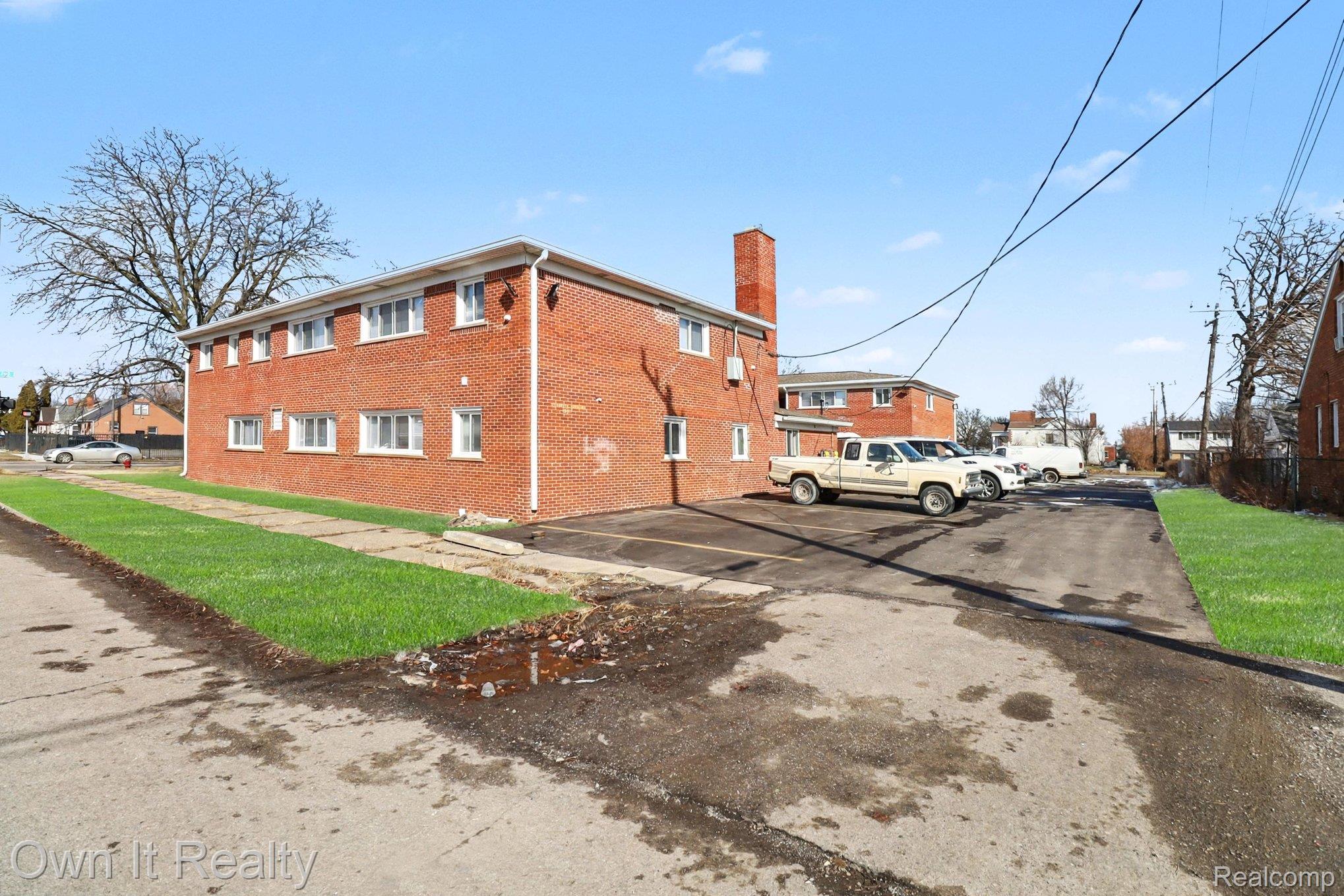 3 Joy Road, Unit 3 Detroit, MI 48228 - Photo 5 of 37 View of property exterior featuring a chimney, brick siding, uncovered parking, and a yard