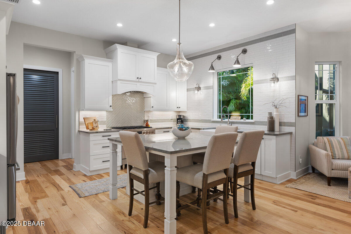 54 Ocean Way Drive Ponce Inlet, FL 32127 - Photo 13 of 76 a kitchen with stainless steel appliances kitchen island granite countertop a dining table chairs and a refrigerator
