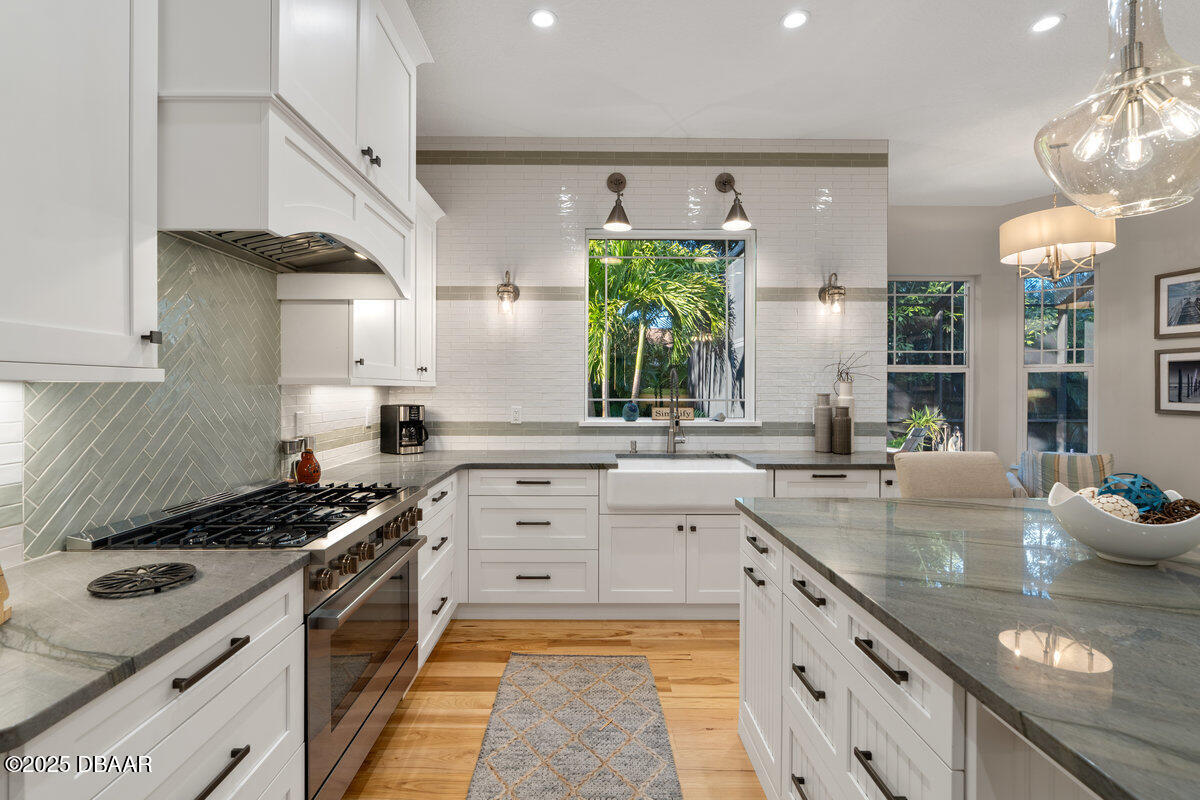 54 Ocean Way Drive Ponce Inlet, FL 32127 - Photo 15 of 76 a kitchen with kitchen island granite countertop a sink stove and cabinets