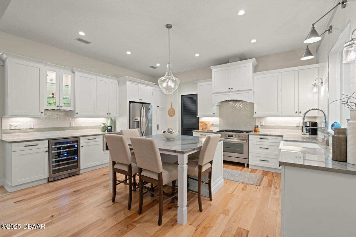 54 Ocean Way Drive Ponce Inlet, FL 32127 - Photo 17 of 76 a kitchen with stainless steel appliances kitchen island granite countertop a wooden floor and white cabinets
