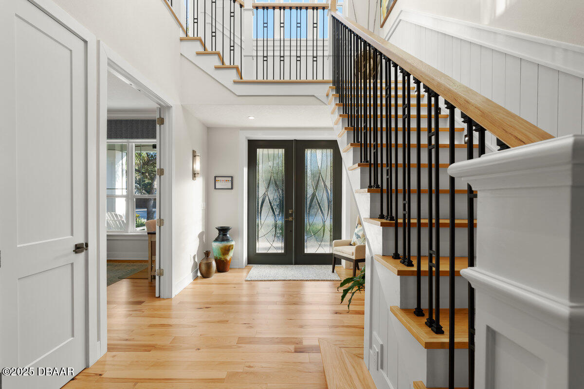 54 Ocean Way Drive Ponce Inlet, FL 32127 - Photo 3 of 76 a view of staircase with lots of frames on wall and a chandelier