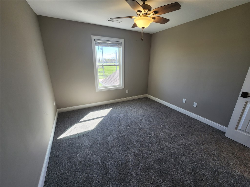 7441 Dodson Road Brookville, OH 45309 - Photo 27 of 50 This spacious room features a ceiling fan, plush carpet, and a bright window with scenic outdoor views.
