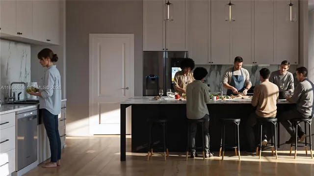 a view of a kitchen with stainless steel appliances kitchen island granite countertop a table and chairs in it