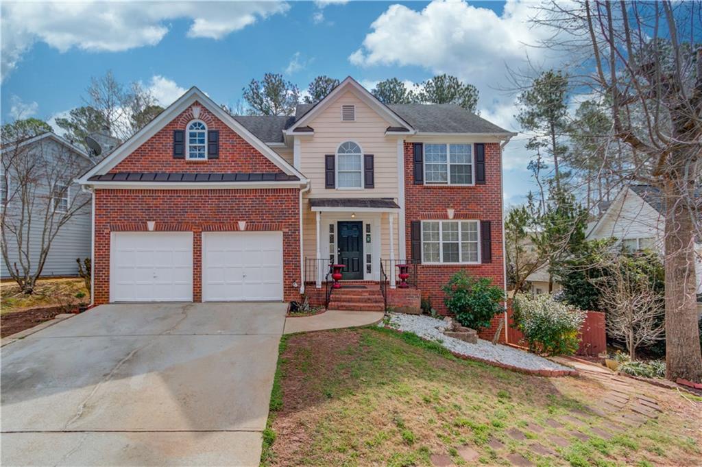 2884 Maple Walk Court Southwest Lawrenceville, GA 30044 - Photo 1 of 1 a front view of a house with garden