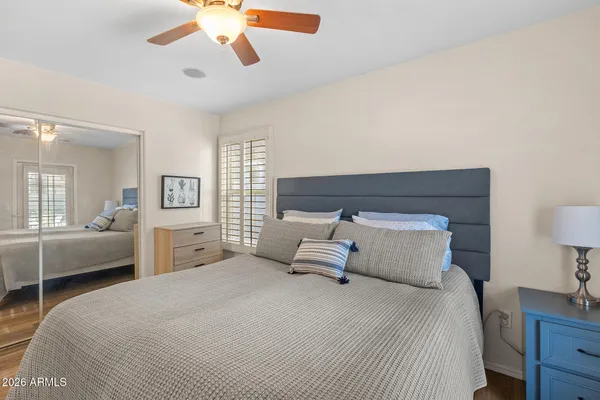 a bedroom with a bed and a flat tv screen on dresser