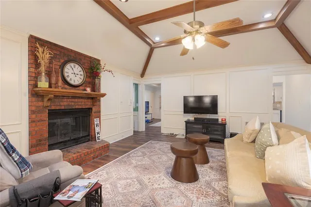 a living room with furniture a fireplace and wooden floor