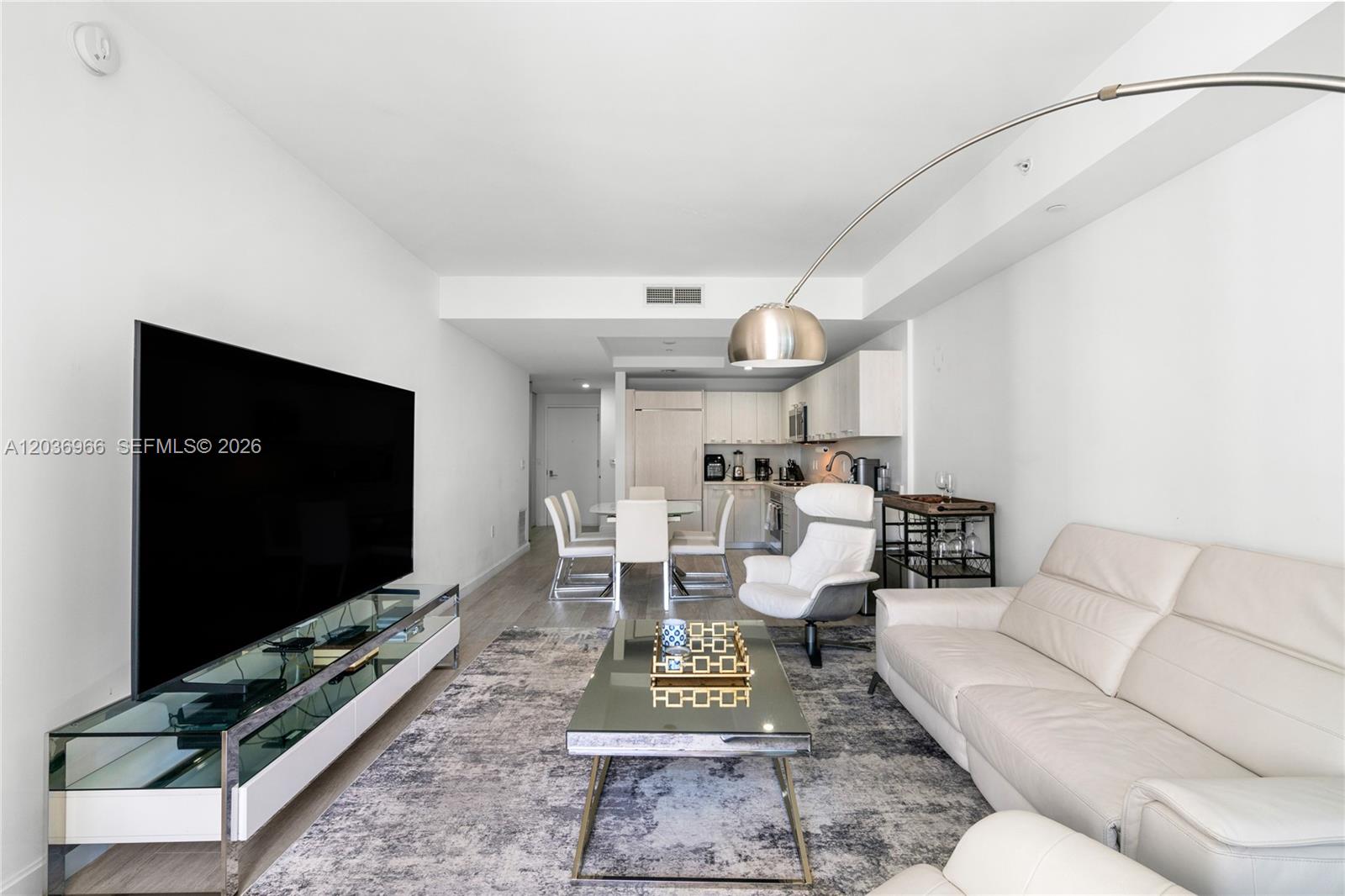 55 Southwest 9th Street, Unit 1904 Miami, FL 33130 - Photo 16 of 66 a living room with furniture a rug and a flat screen tv