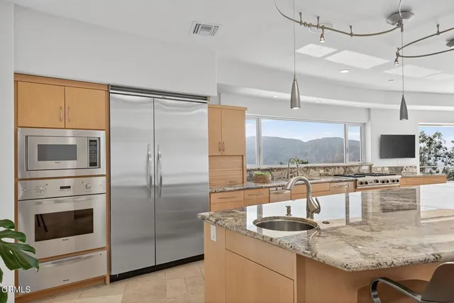 a bathroom with a granite countertop sink and mirror