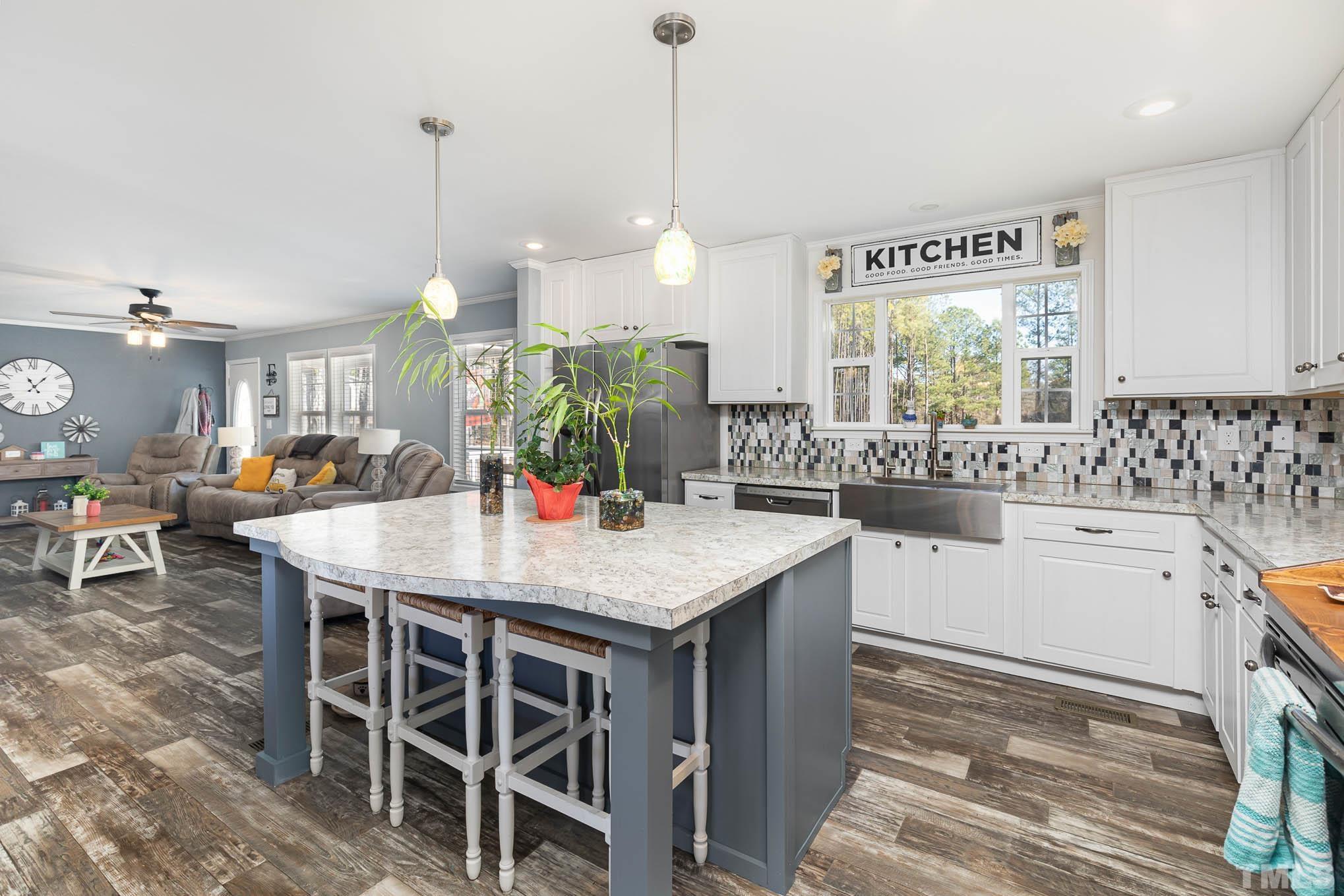 2917 Edgemont Road Wendell, NC 27591 - Photo 12 of 27 a room with stainless steel appliances kitchen island granite countertop a table chairs and a view of living room