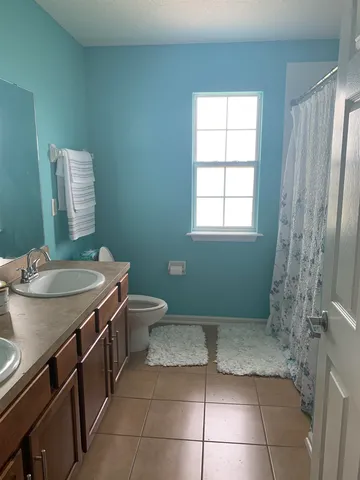 a bathroom with a granite countertop sink a toilet and a mirror