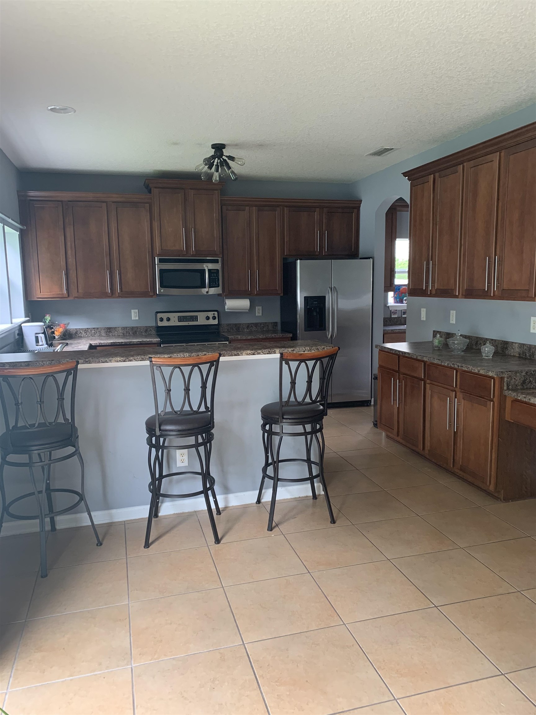 619 South Tree Garden Drive St. Augustine, FL 32086 - Photo 7 of 21 a kitchen with kitchen island granite countertop wooden cabinets a dining table and chairs