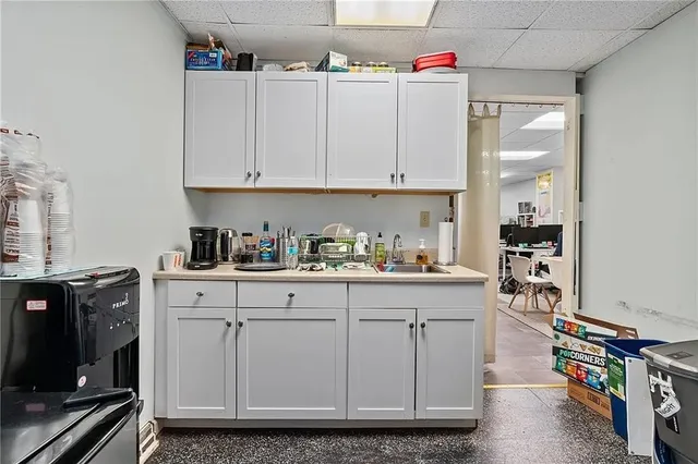 a kitchen with white cabinets and sink