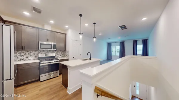 a large kitchen with kitchen island a sink stainless steel appliances and cabinets