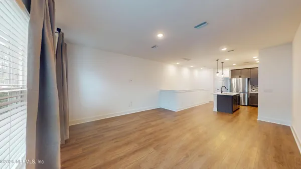 a view of a big room with wooden floor and a window