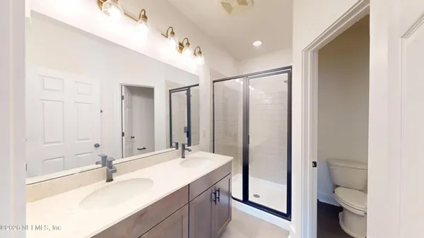 a bathroom with a double vanity sink mirror and toilet