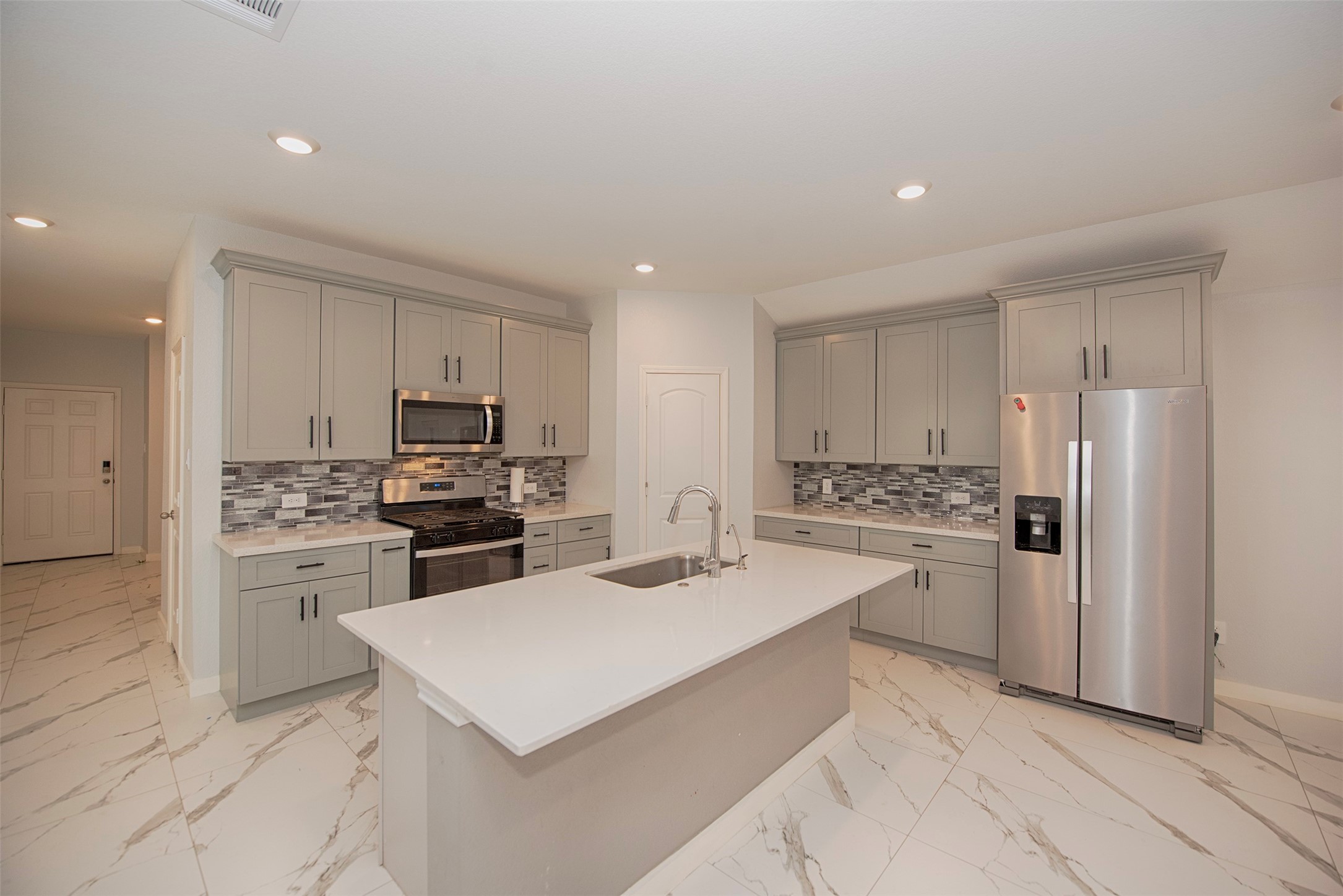 15223 Mayflower Street New Caney, TX 77357 - Photo 13 of 42 a kitchen with a refrigerator a stove top oven a sink and cabinets
