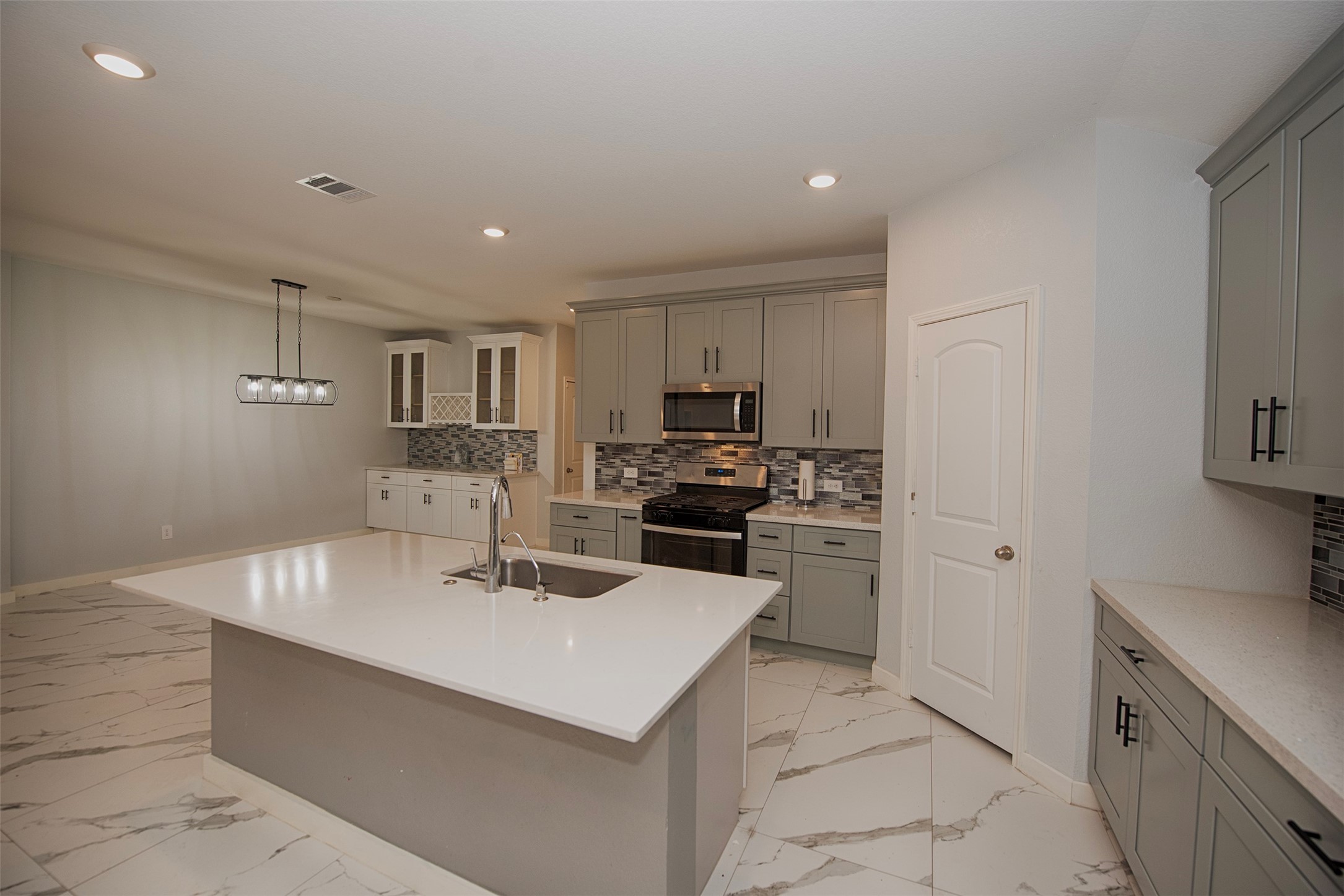 15223 Mayflower Street New Caney, TX 77357 - Photo 15 of 42 a kitchen with a sink a stove top oven and white kitchen
