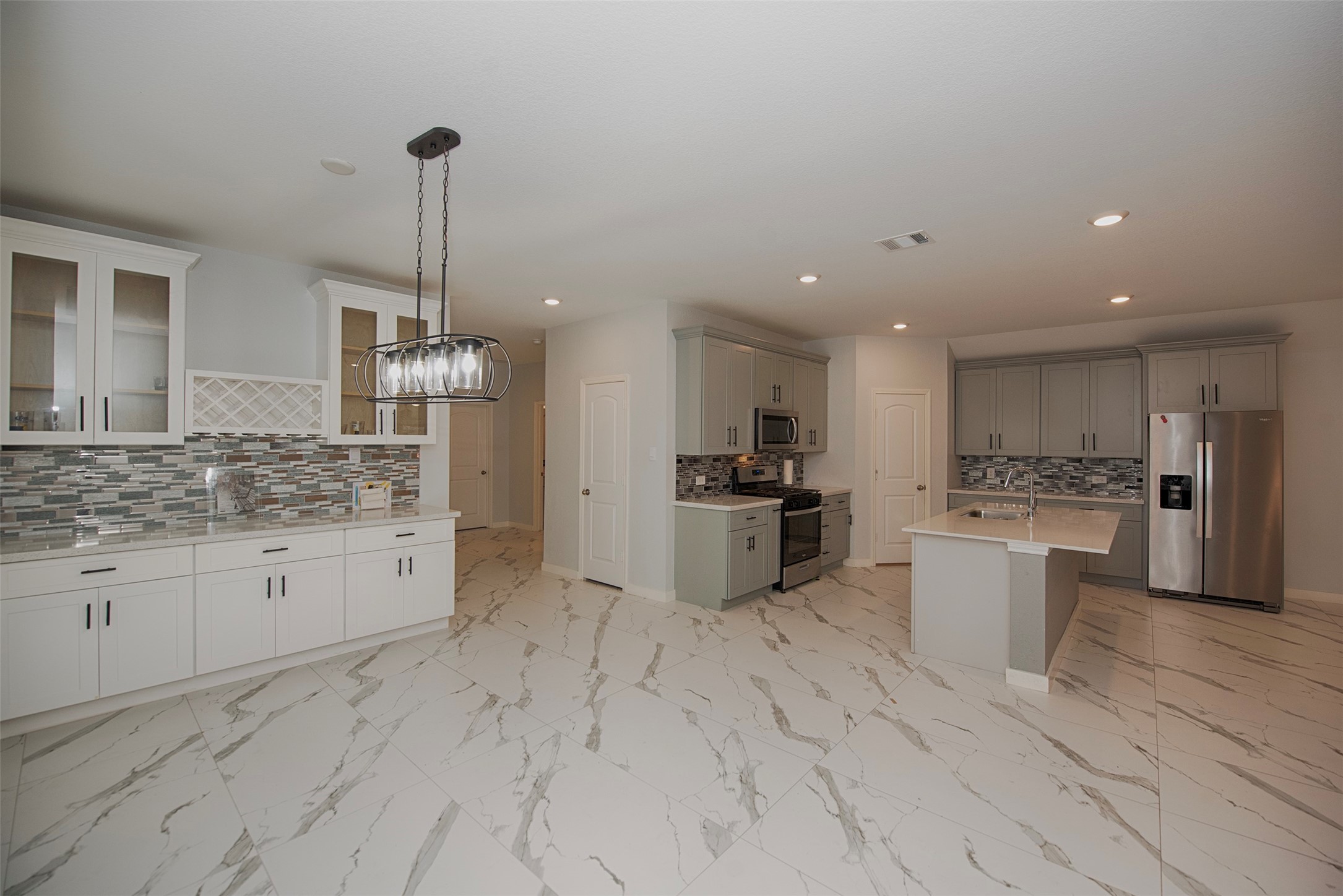 15223 Mayflower Street New Caney, TX 77357 - Photo 8 of 42 a large kitchen with stainless steel appliances kitchen island granite countertop a sink and cabinets