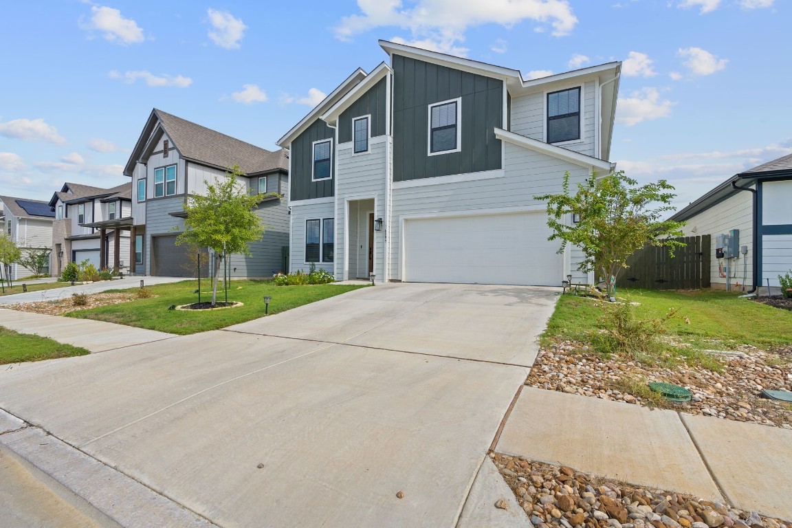 a front view of a house with a yard and potted plants