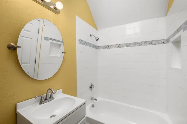 a bathroom with a sink a mirror and a bathtub