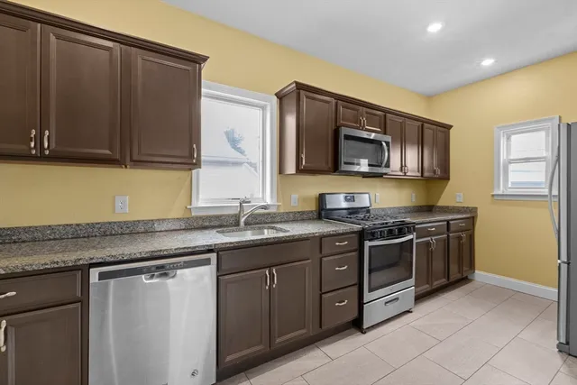a kitchen with stainless steel appliances granite countertop a stove a sink and a microwave