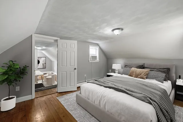 a bedroom with a large bed and a potted plant