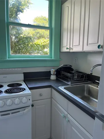 a kitchen with a sink a stove and cabinets