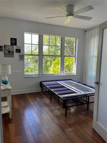 a room with wooden floor pool table and windows