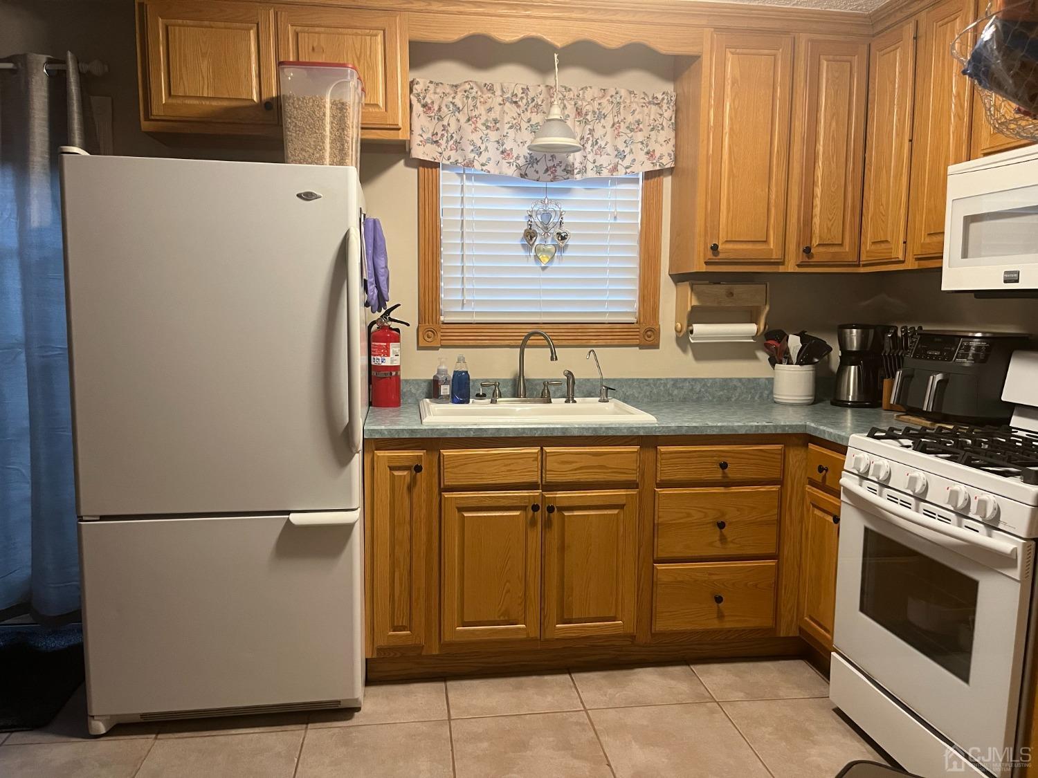 80 Greenwood Loop Road, Unit 80 Brick, NJ 08724 - Photo 11 of 38 a kitchen with a refrigerator and cabinets