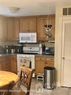 80 Greenwood Loop Road, Unit 80 Brick, NJ 08724 - Photo 10 of 38 a kitchen with a stove and a refrigerator