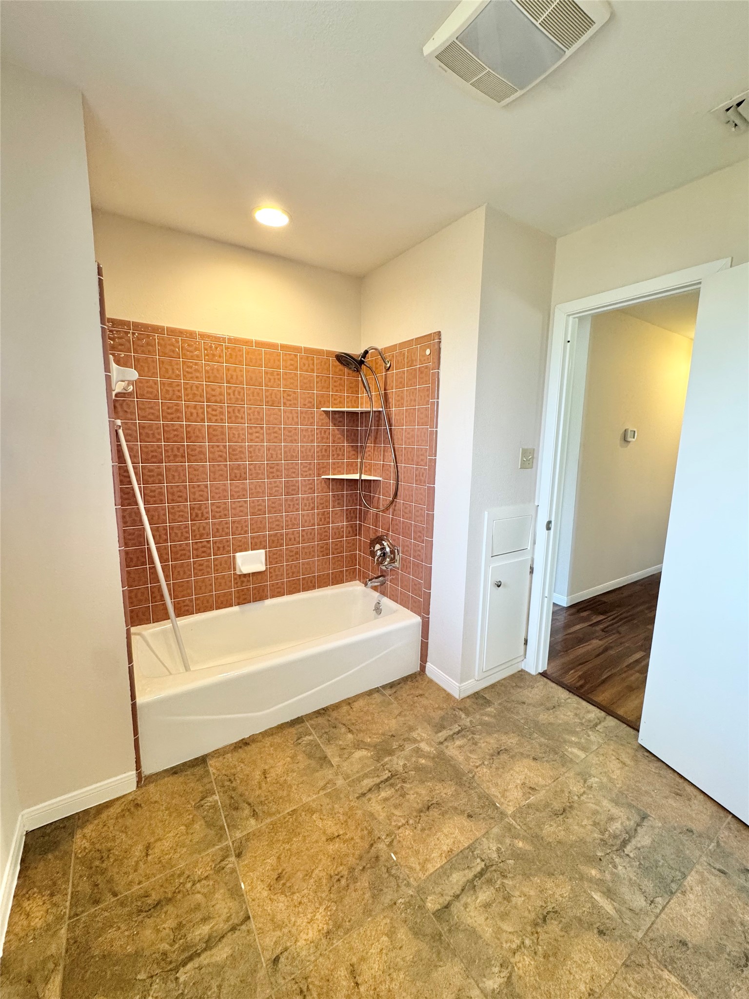 18512 Carlson Lane Elgin, TX 78621 - Photo 21 of 29 Tiled flooring pairs with a classic shower-tub combination in this practical bathroom space.