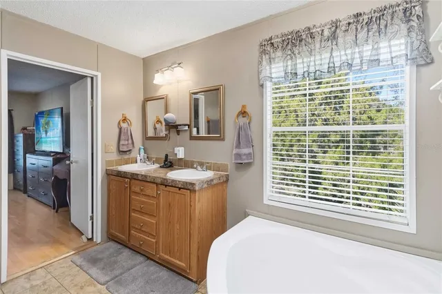 a bedroom with a granite countertop sink and a large mirror