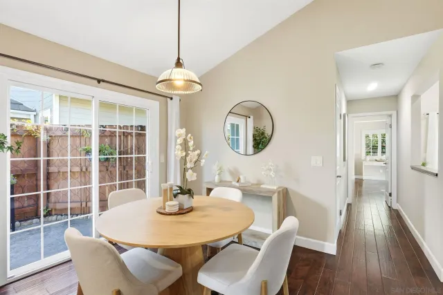 a dining room with wooden floor a chandelier a wooden table and chairs