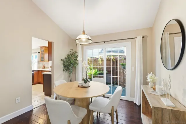 a dining room with furniture a chandelier and wooden floor