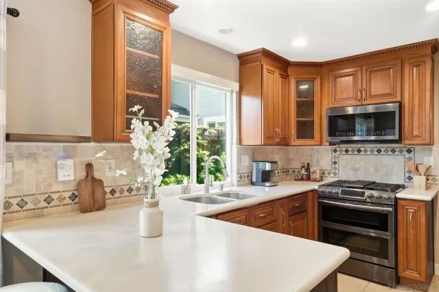 a kitchen with stainless steel appliances granite countertop a sink stove and microwave