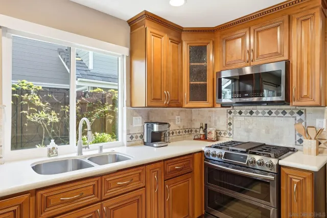a kitchen with granite countertop a sink stove and cabinets