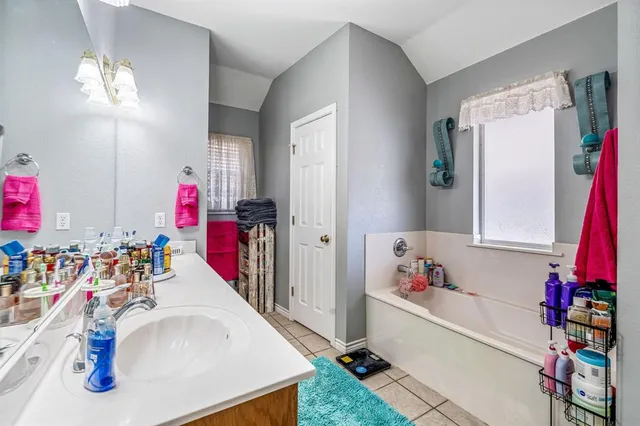 a bathroom with a tub sink and a mirror