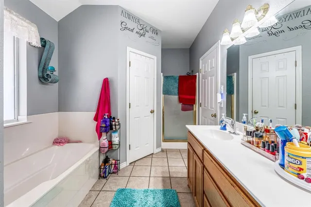 a bedroom with a bed lamps and a large mirror on the dresser