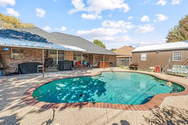 a view of a house with swimming pool and sitting area