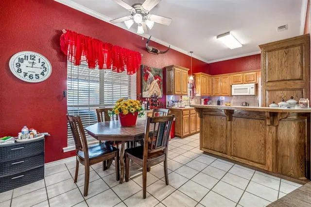 a dining hall with granite countertop a dining table chairs and a chandelier