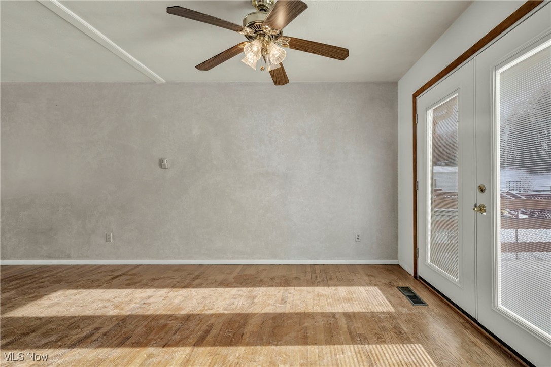 2514 Primewood Road Akron, OH 44305 - Photo 10 of 49 Empty room featuring french doors, wood finished floors, and a ceiling fan