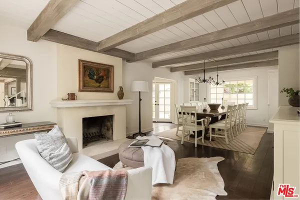 a living room with furniture a fireplace and a floor to ceiling window