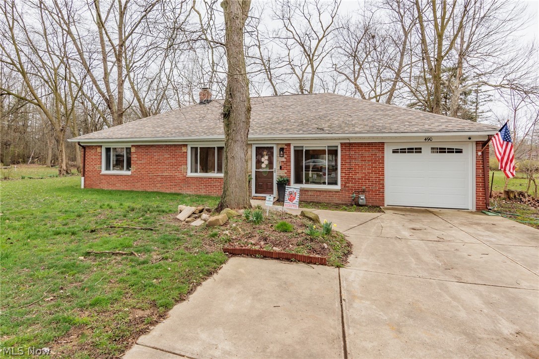 Ranch-style home with a front yard and a garage